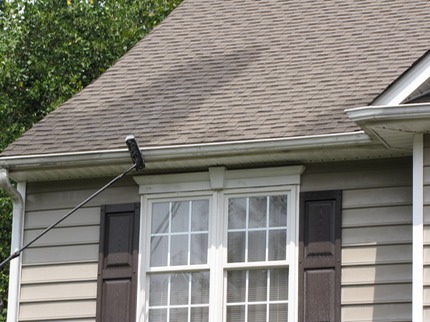 Marc’s on the Glass hand cleaning gutters with black stain and stripes in Richmond, VA - restoration